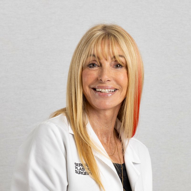 Medical headshot of a smiling clinician in a white lab coat