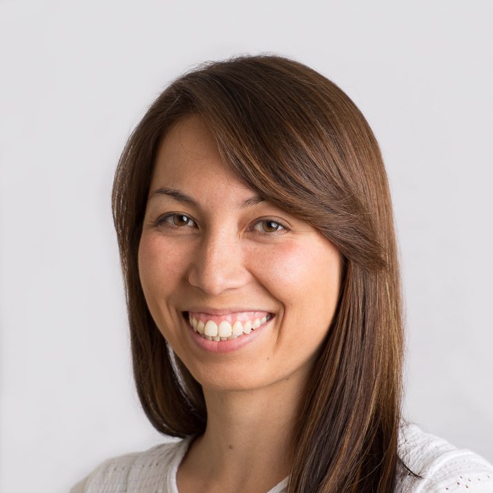 On-location headshot of a smiling professional woman on a bright background